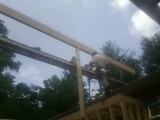 Carpenter setting a ridge beam over a new addition frame — Ice Dam Removal by Roofing Brothers in Coplay