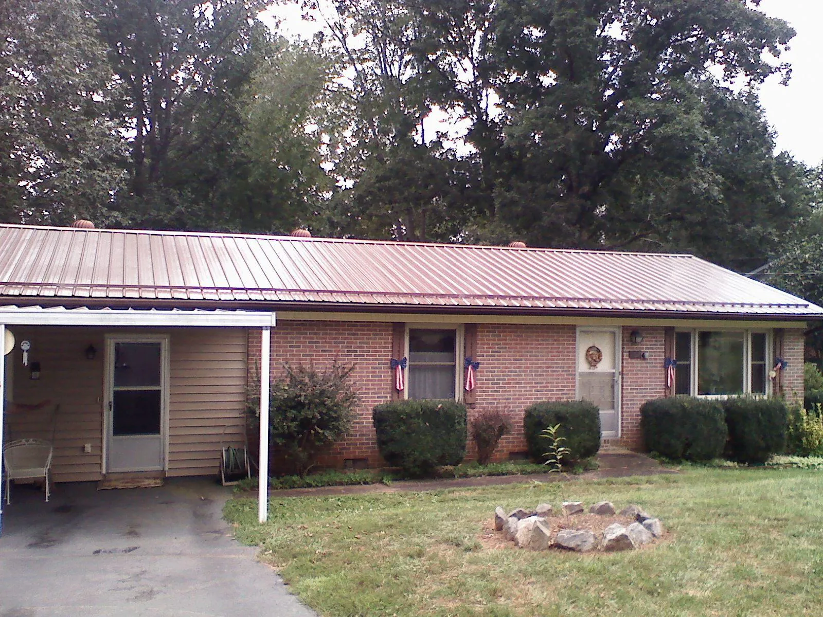 Bronze metal roof and carport on a brick ranch home — Roof Repair work by our crew in Coplay